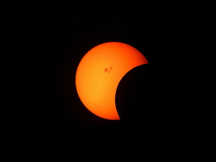 The moon beginning to eclipse the sun